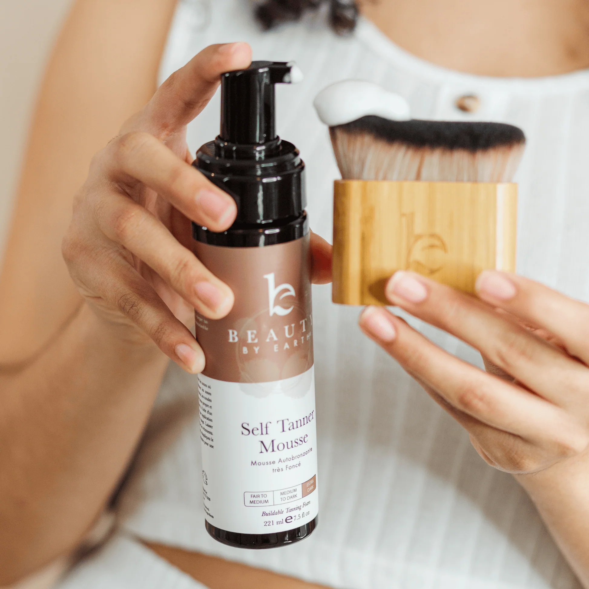 A woman using a self-tanner at home with a professional product