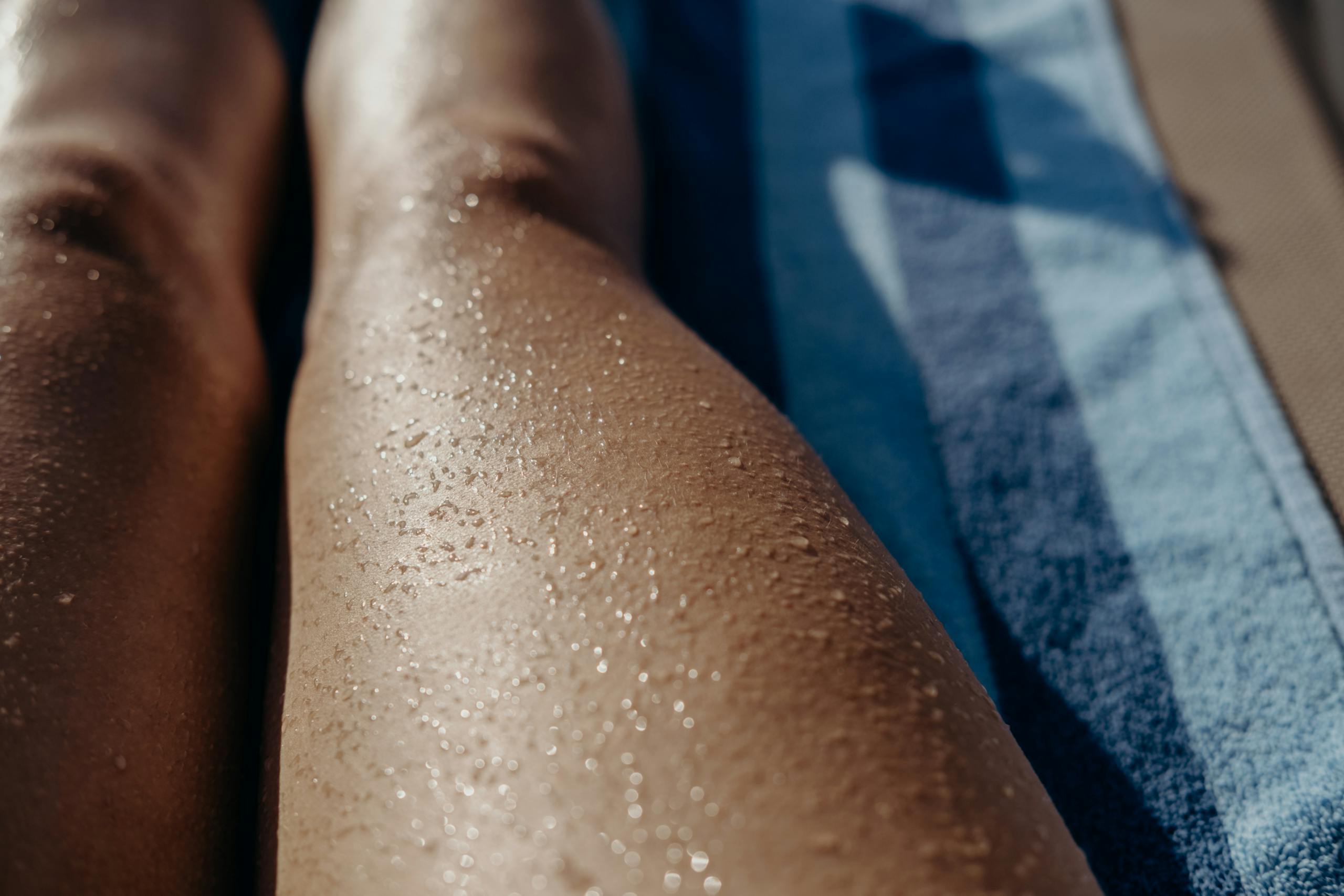Close-up image of wet legs on a towel, capturing summer relaxation.