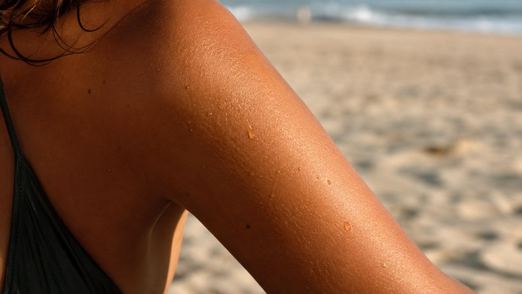 tanning oil absorbing into bronzed skin in natural sunlight
