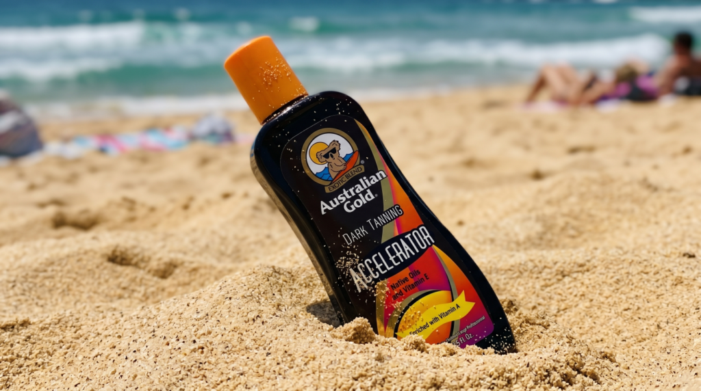 Australian Gold Dark Tanning Accelerator bottle in beach sand with ocean in the background